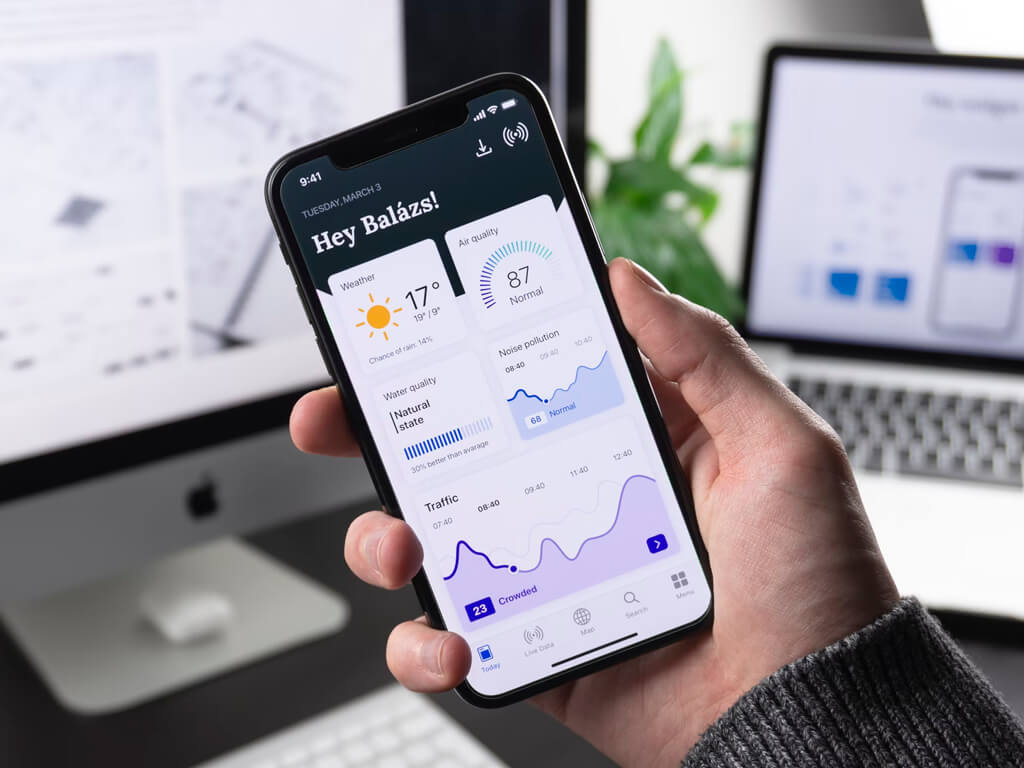 Hand holding a smartphone that shows the app dashboard