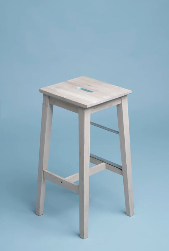 Wooden stool against a blue wall