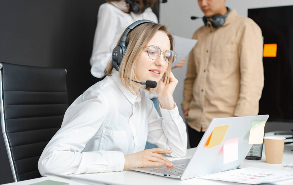 Support specialist wearing a headset while working at a laptop